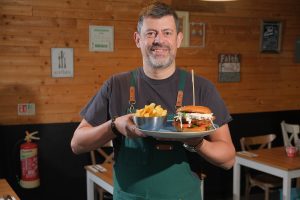 A member of the Kitchen Lurgan team carrying freshly plated meals